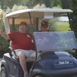 A Man in a Red Top in a Golf Cart