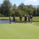 A Group of Men Standing With Gold Clubs in Hand