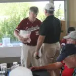 Two Men in Golf Attire Talking in a Restaurant