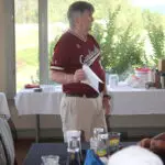 A Man Talking to a Group of People in a Maroon Color Top