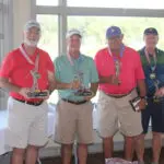 Four Men Standing With Medals and Trophies