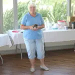 A Woman in a Light Blue Color Top Holding a Trophy