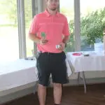 A Man in a Pink Color Top Holding a Trophy