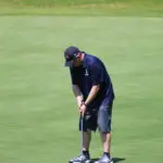 A Man in a Navy Blue Top and Shorts Playing Golf