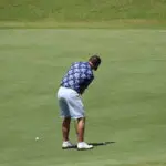 A Man in a Blue Shade Top and White Shot Playing Golf