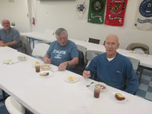 A Group of People Sitting by a Stand