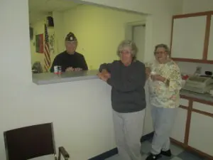 Two Elderly Women Standing in Front of a Stand