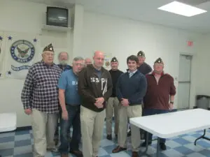 A Group of Men Standing by a White Color Table