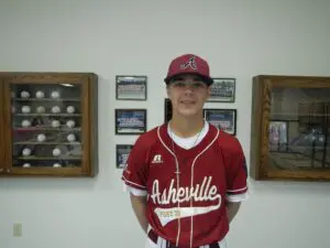 Corey Norton, smiling in a red shirt and cap.