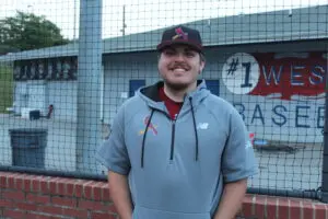 Asst Coach Nate Toney smiling wearing a cap